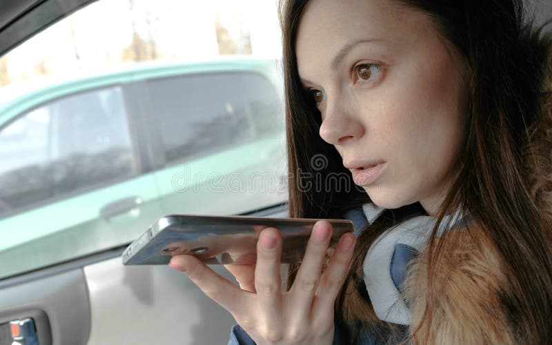 Young beautiful woman speak a voice message on a mobile phone sitting in the car. stock images Young beautiful woman speak a voice message on a mobile phone sitting in the car. stock images