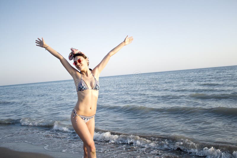 Young beautiful woman in swimsuit standing on the beach. royalty free stock photos Young beautiful woman in swimsuit standing on the beach. royalty free stock photos