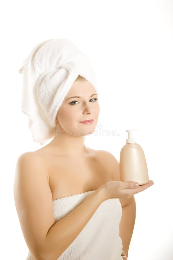 Young beautiful woman in towel with lotion