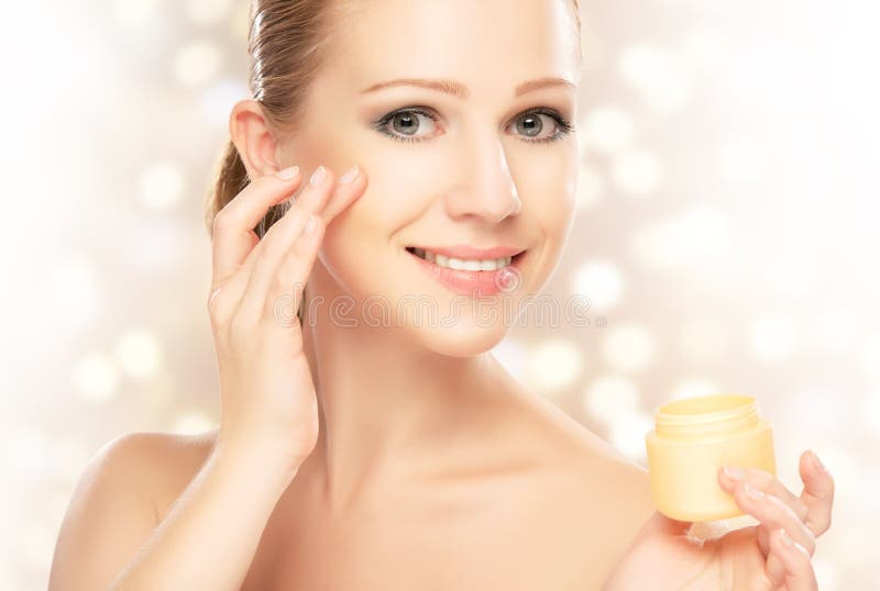 Young beautiful woman using a face cream