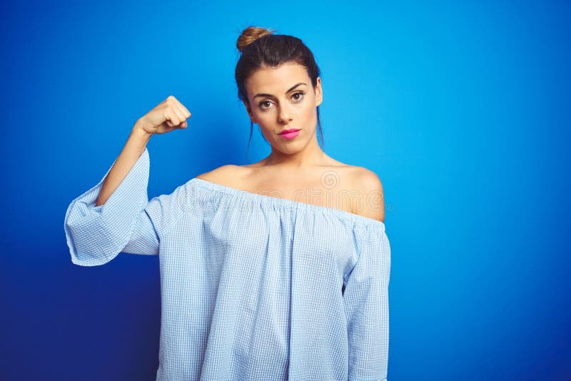 Young Beautiful Woman Wearing Bun Hairstyle Over Blue Isolated Background Strong  Person Showing Arm Muscle, Confident and Proud of Stock Image - Image of  lifestyle, beautiful: 228137917