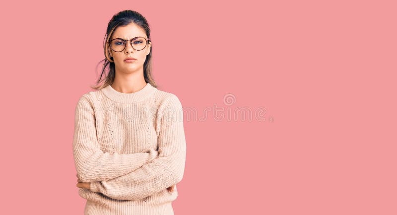 Young beautiful woman wearing casual winter sweater and glasses skeptic and nervous, disapproving expression on face with crossed