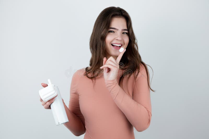 sexy girl holding strawberry with whipped cream isolated on pink