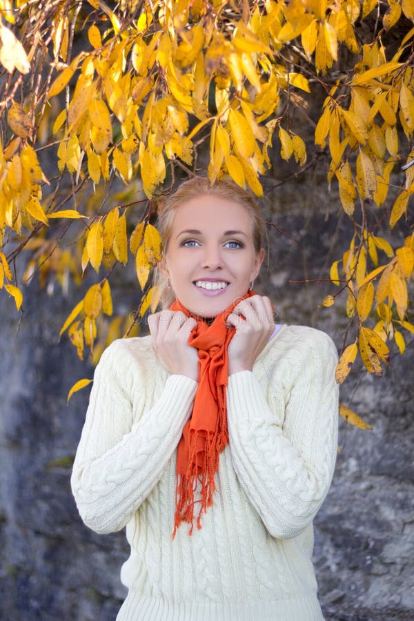 Young Beautiful Woman In White Sweater Posing Against Stone Wall Stock