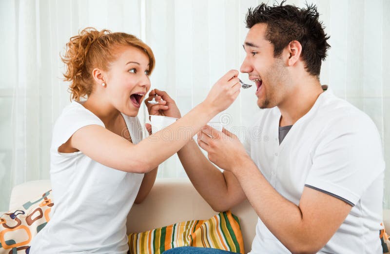 Young, beauty girl and boy eating yoghurt