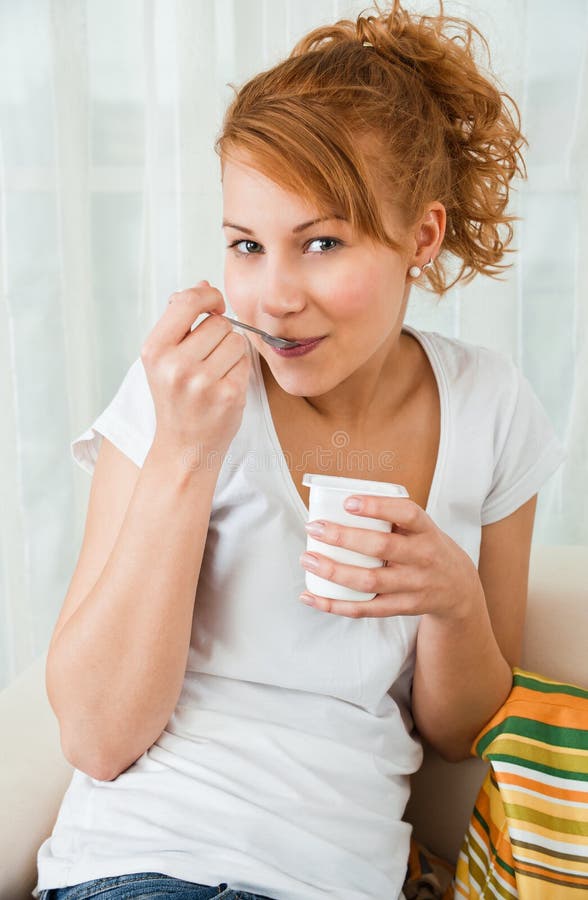 Young, beauty girl eating yoghurt