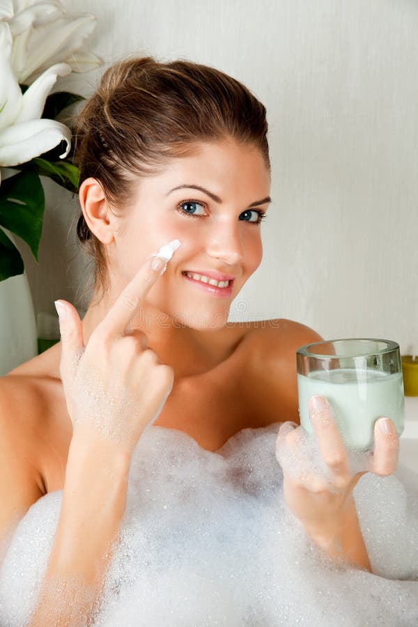 Young beauty woman in the bath using face mask
