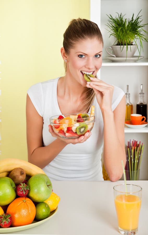 Young beauty woman eating fruit salad