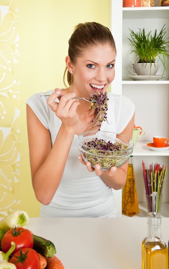 Young beauty woman eating sprouts