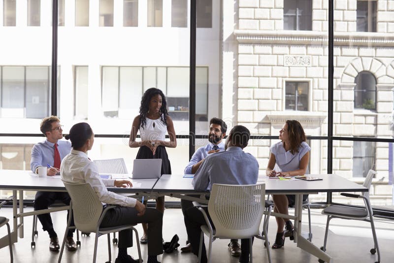 Young black businesswoman addressing colleagues at a meeting royalty free stock photo Young black businesswoman addressing colleagues at a meeting royalty free stock photo