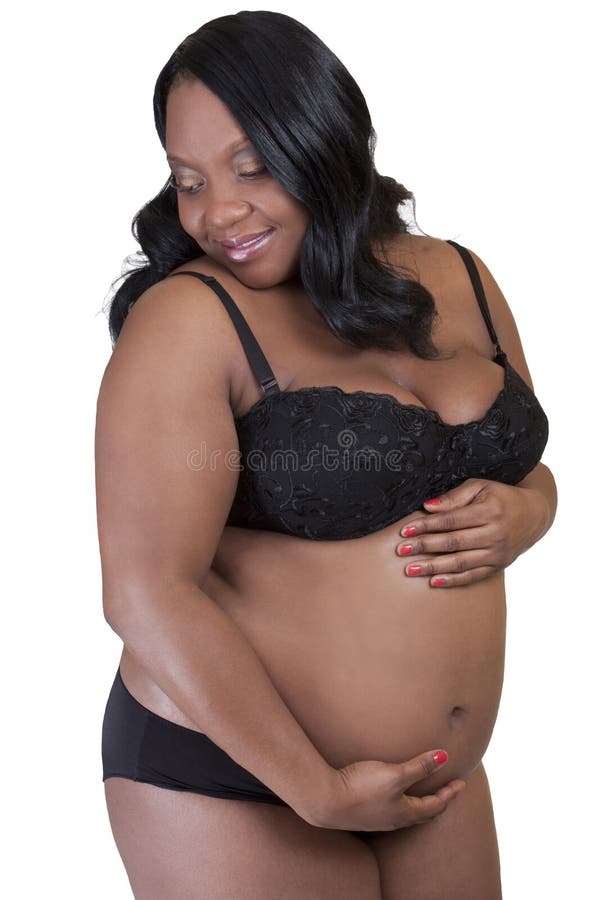 Happy pregnant woman in bra and panties holding stomach stock photo