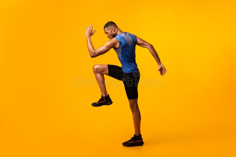 Young black sportsman walks highly lifting knees