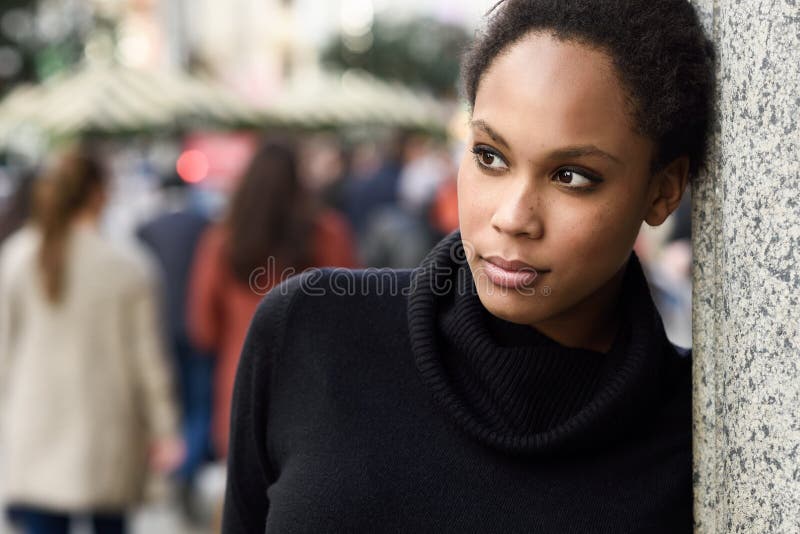 Young black woman with afro hairstyle standing in urban background stock photo Young black woman with afro hairstyle standing in urban background stock photo