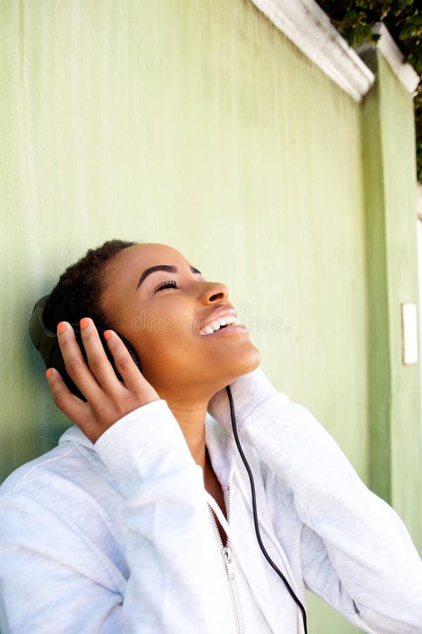 Young black woman listening to music with headphones