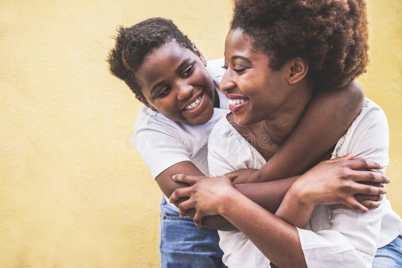 Young black woman using smart mobile phone - African girl laughing and smiling using web app on cellphone - Female lifestyle and