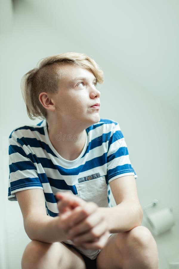 Boy Sitting On Toilet Looking At Magazine Side View Stock 