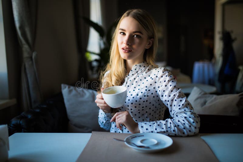 Young blond woman enjoying coffee time in cafe stock photography Young blond woman enjoying coffee time in cafe stock photography