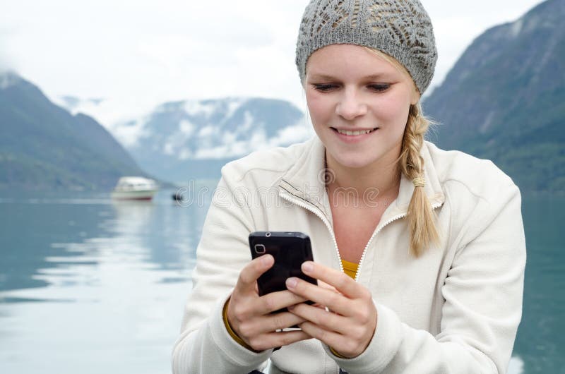 Young blond woman with her Smartphone in the hand