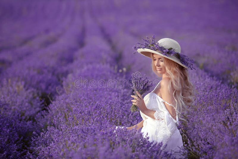 Young blond woman in lavender field. Happy carefree female in a