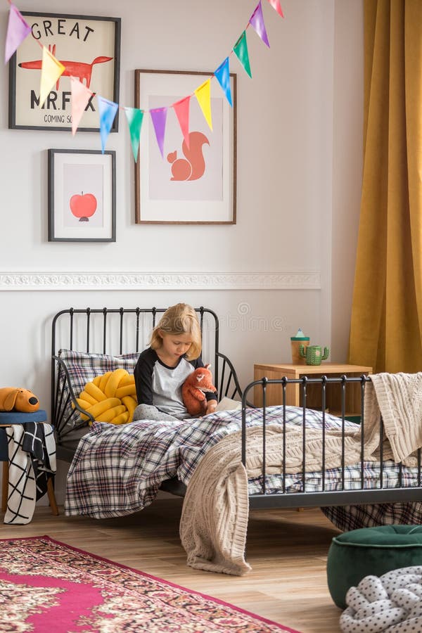 Young girl sitting on her bed in retro styled room