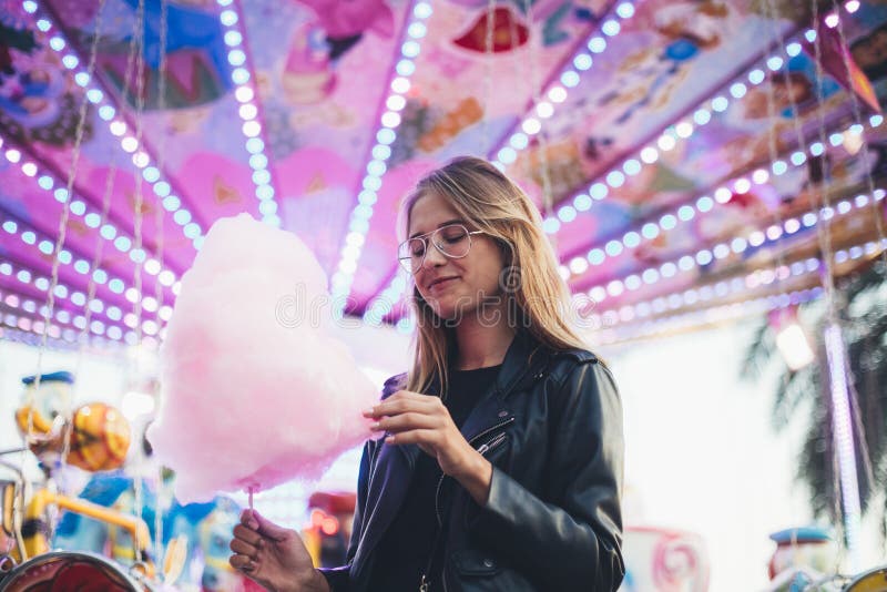 Young blonde woman eats cotton candy floss stock photos Young blonde woman eats cotton candy floss stock photos