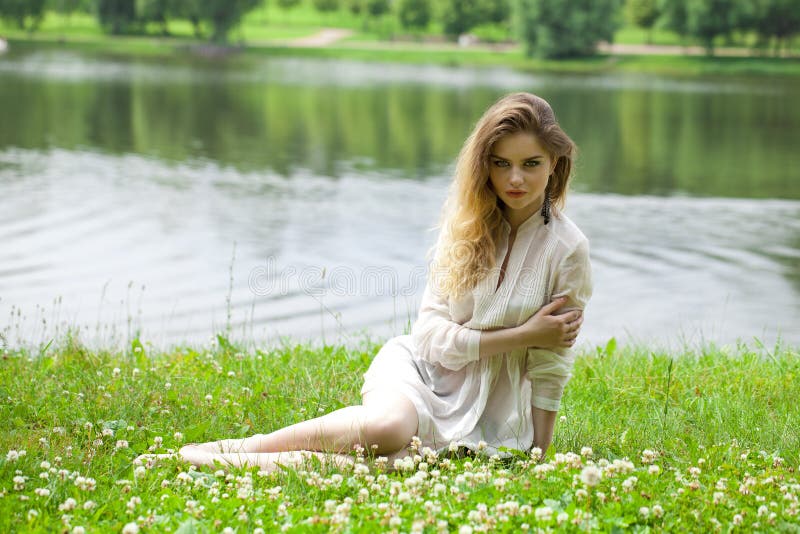 Young blonde woman on green meadow