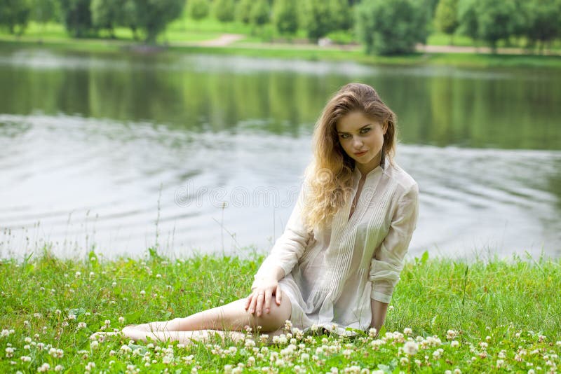 Young blonde woman on green meadow