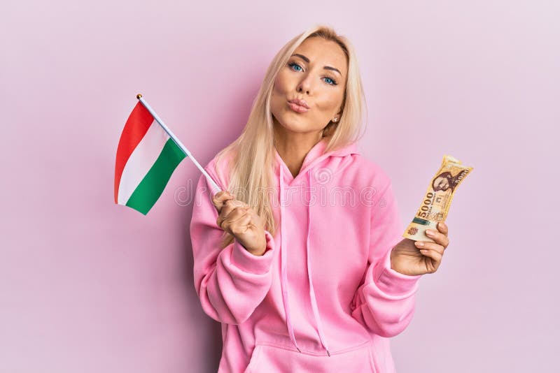 Young Blonde Woman Holding Hungary Flag And Forint Banknotes Looking At