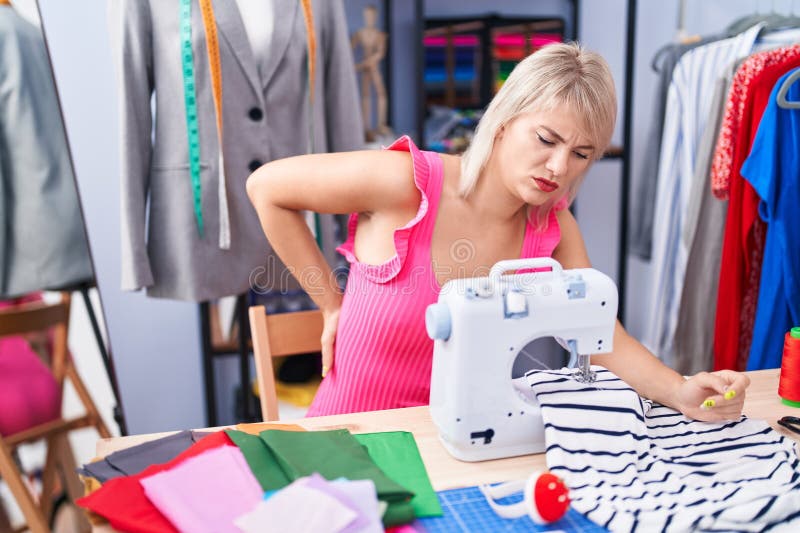 Young Blonde Woman Tailor Stressed Using Sewing Machine at Gaming Room