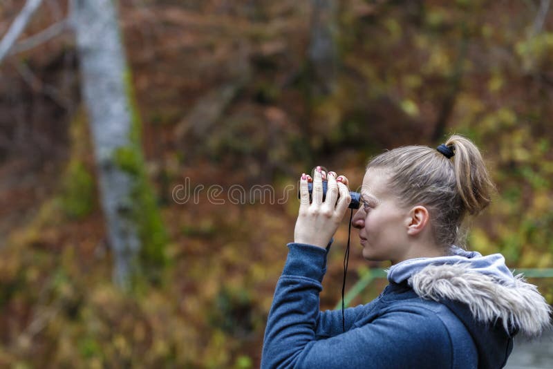 Young Blonde Woman Tourist on a Cliff Looking through Binoculars Stock ...