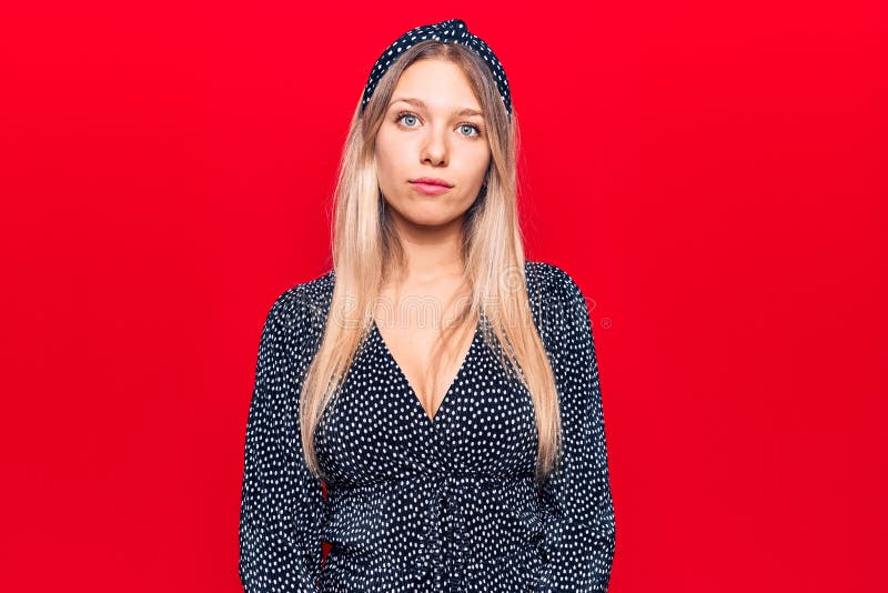 Young blonde woman wearing casual clothes with serious expression on face