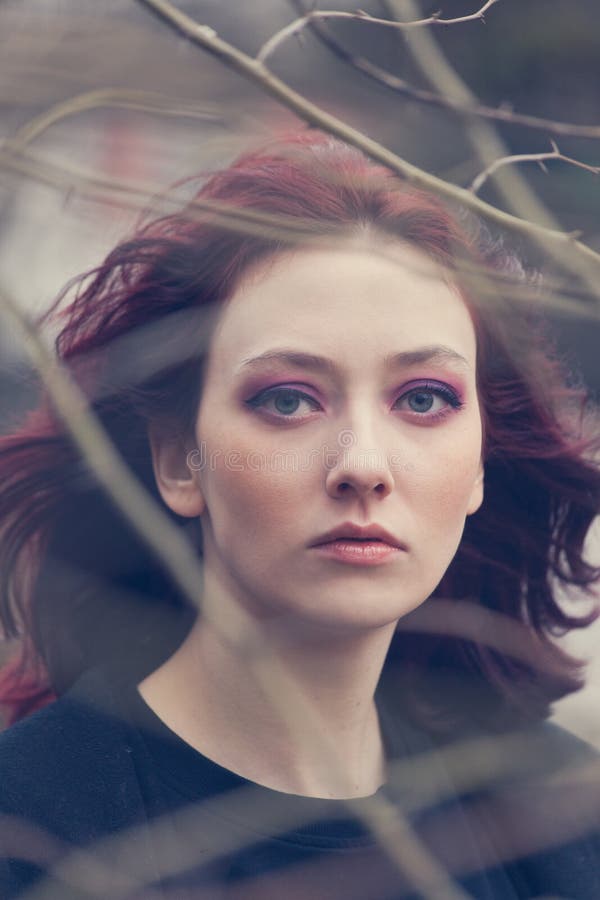 Young blue eyes woman portrait through the tree branch outdoor natural light closeup wind blows royalty free stock photos Young blue eyes woman portrait through the tree branch outdoor natural light closeup wind blows royalty free stock photos