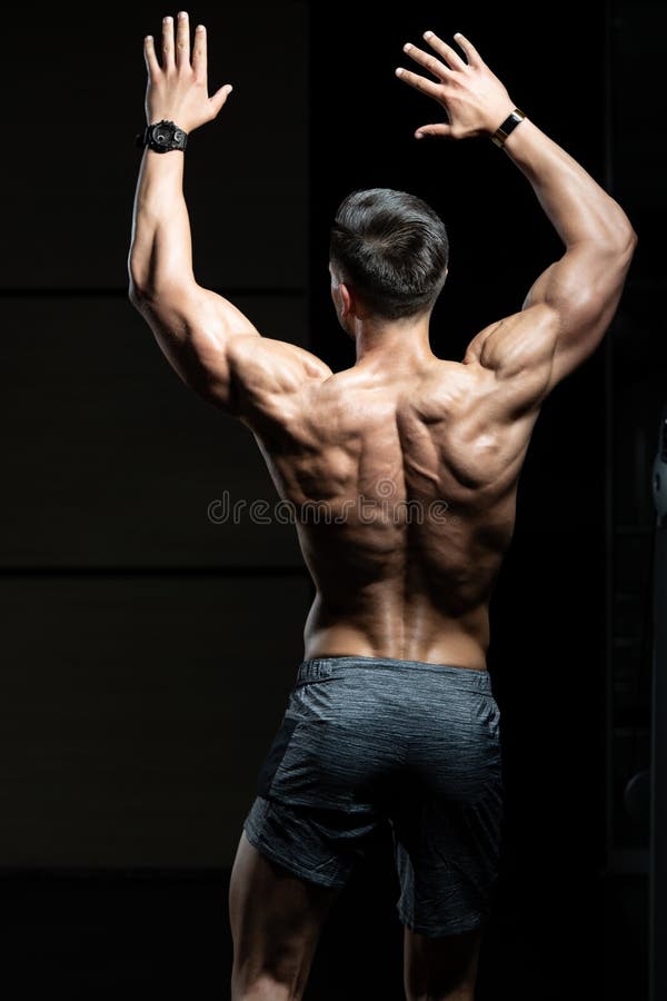 Strong muscular man bodybuilder poses and shows his muscles Stock Photo |  Adobe Stock