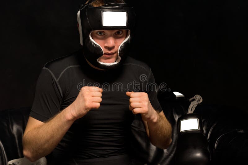 Young boxer psyching himself up as he dresses in his gear and prepares himself for the fight staring ahead with a look of concentration