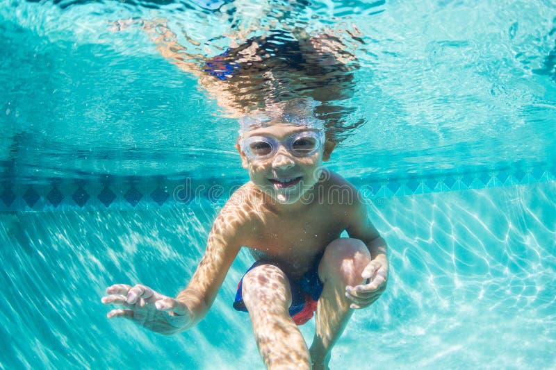 Young Boy Diving Underwater in Swimming Pool