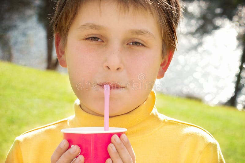 Boy drinking milk through silly straw glasses, while looking up Stock Photo