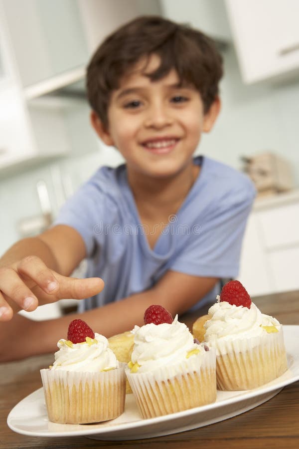 Young Boy Eating Cakes in Kitchen Stock Photo Image of caucasian