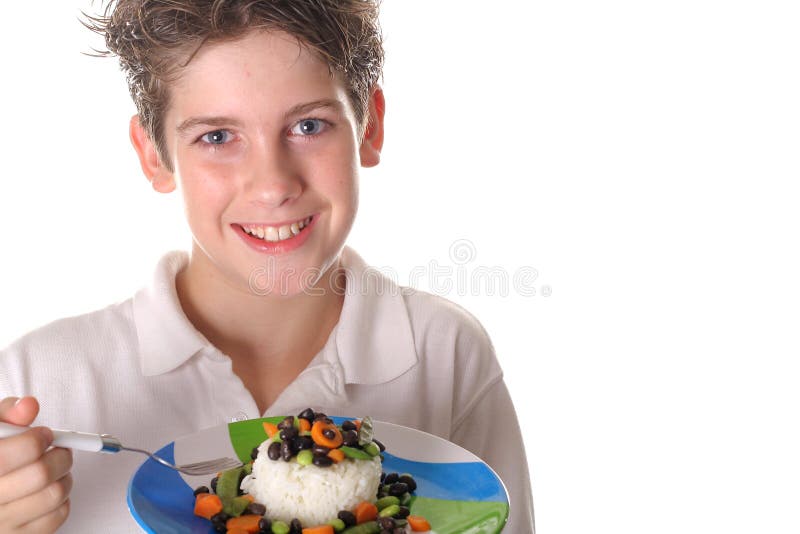 Young boy eating healthy rice, beans & veggies