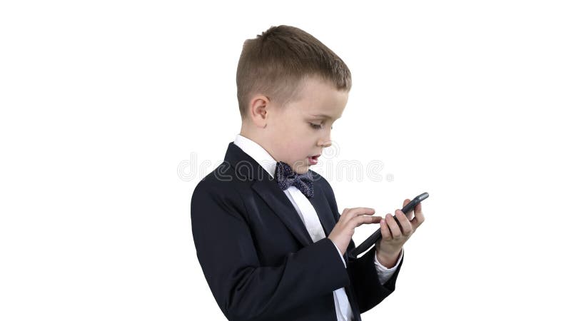 Young boy in elegance suit playing with mobile phone on white background.