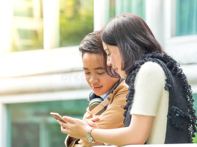 Young boy and girl play games and listen to music on their mobile phones  7468481 Stock Photo at Vecteezy