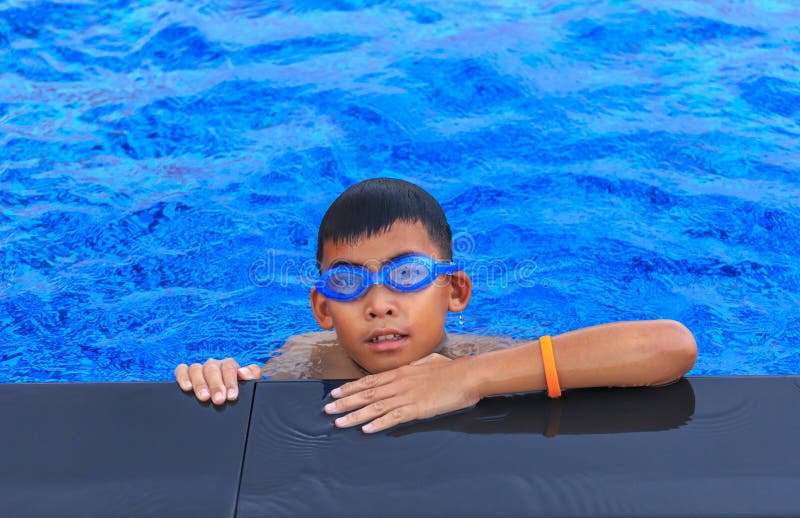 Happy Boy in Cap in Swimming Trunks Stands on the Beach on Golden Sand