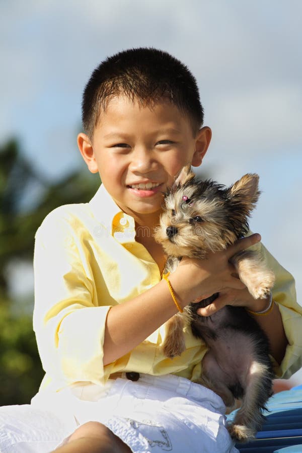 Young boy holding his puppy