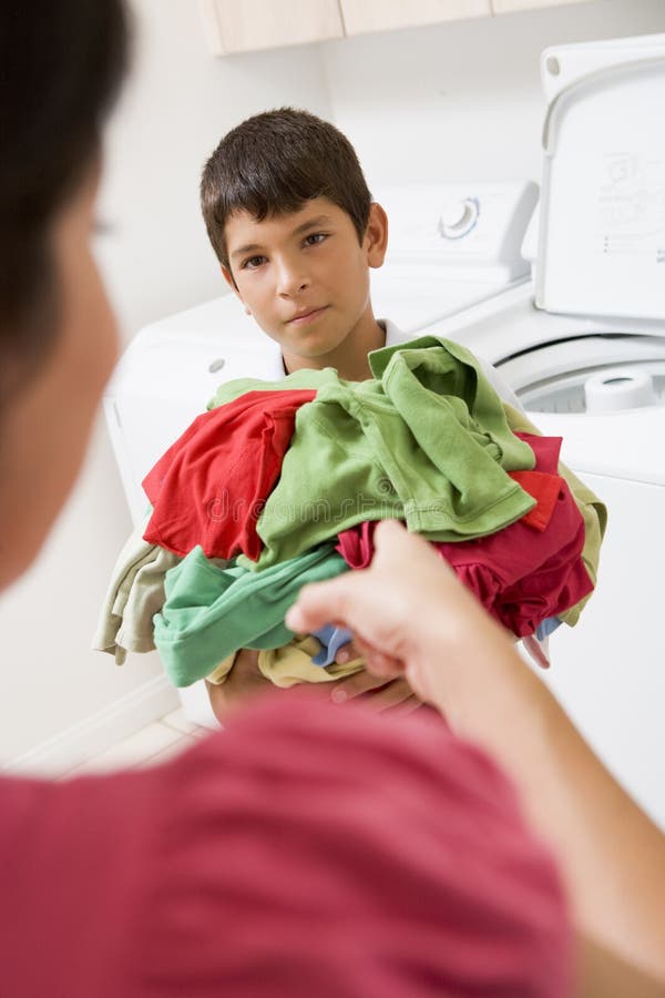 Young Boy Holding a Pile of Laundry Stock Image Image of adolescent, laundry 6881719