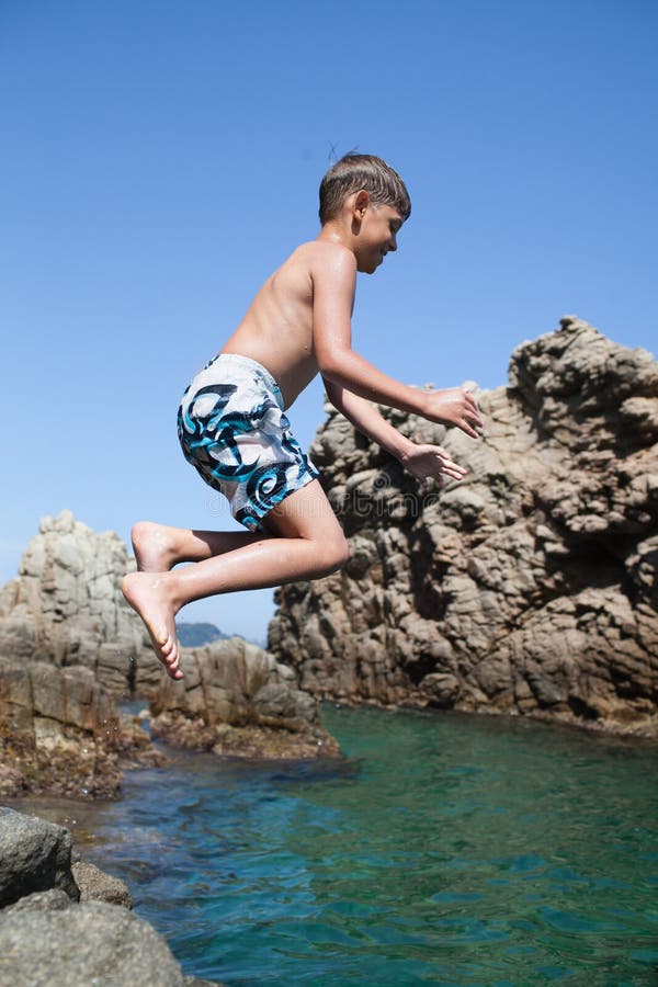 Young boy jumping into the sea