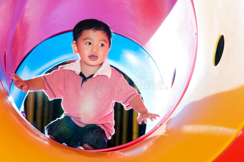 Young Boy Playing In Tube Slide