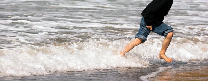 Young Boy Running Feet Ocean Beach Surf Crashing Sea Foam