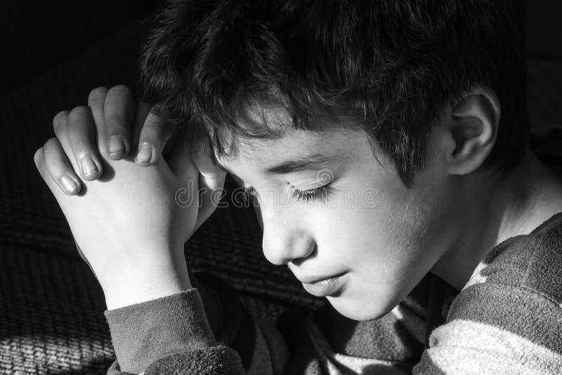 Young Boy Smiling Peacefully As he Says Bedtime Prayers, Black a Stock ...