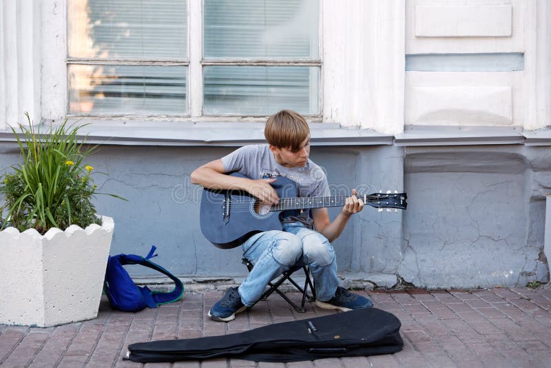 Young boy street musician playing acoustic guitar on the street stock photography Young boy street musician playing acoustic guitar on the street stock photography