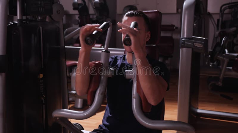 Boy using bodybuilding machine in gym - close up