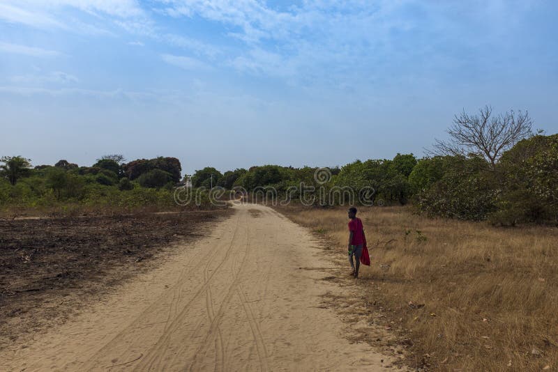 Young boy walking along a dirt road near the village of Eticoga in the island of Orango.